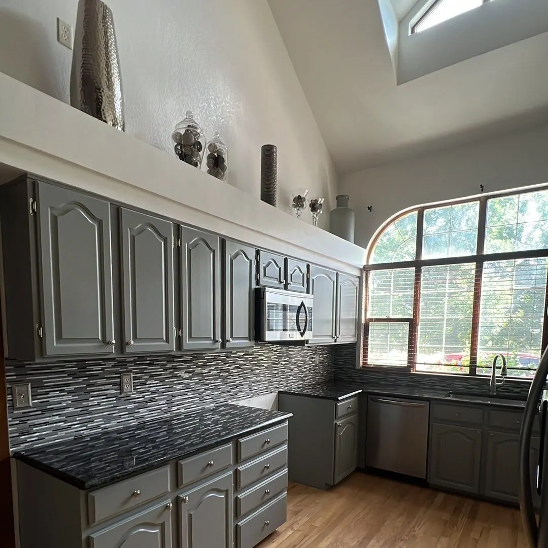 Kitchen cabinets painted in a soft blue-gray after a Kind Home Painting refinish