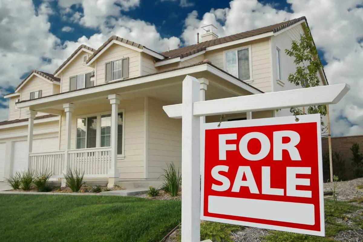 A for sale sign outside a freshly painted home