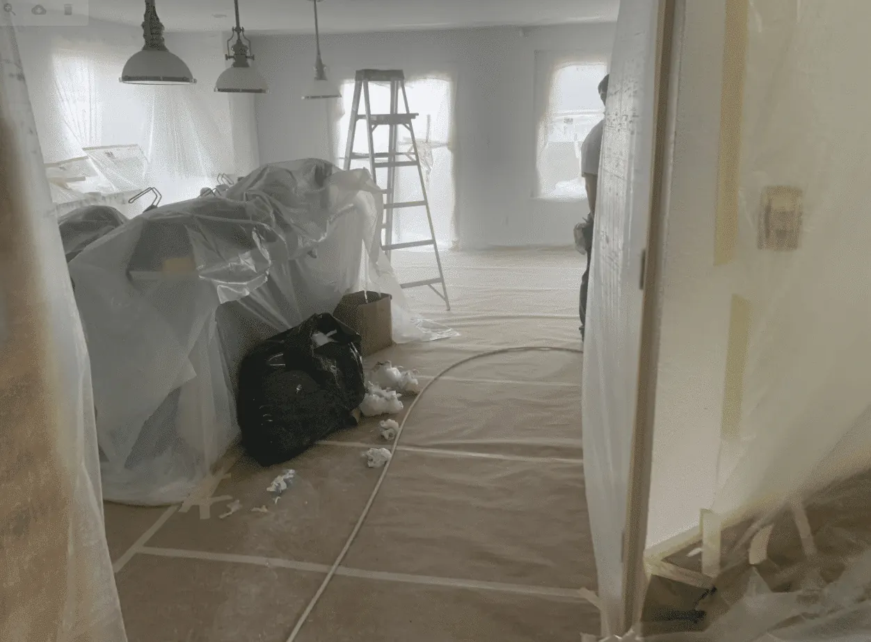 A room prepared for interior painting with furniture covered and floors protected