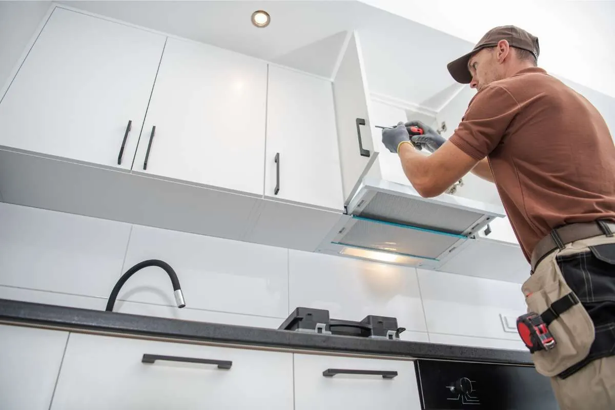 A Kind Home painter hand-detailing installed cabinet doors