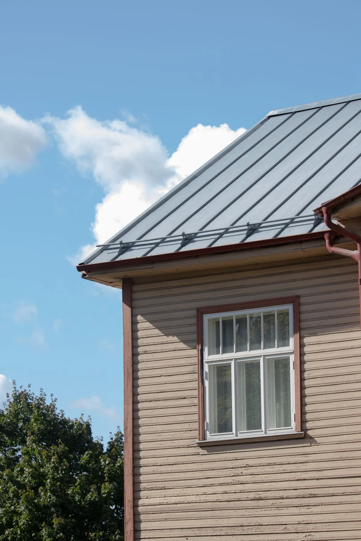 Exterior fascia, corner trim and lap siding at the eave of a painted wood house